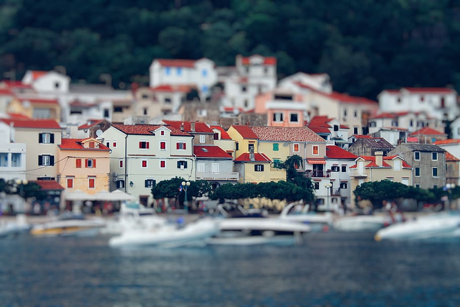 Tilt Shift Lens Photography of Red Roof House Near the Body of Water HD wallpaper