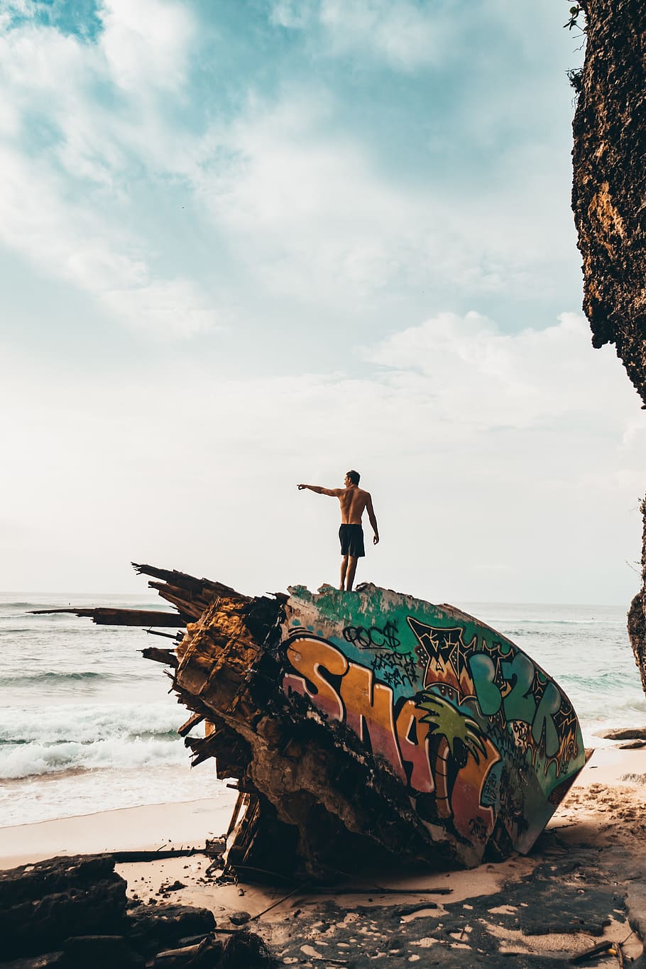 man, pointing, ocean, beach, sand, rock, grafitti, paint, art HD wallpaper