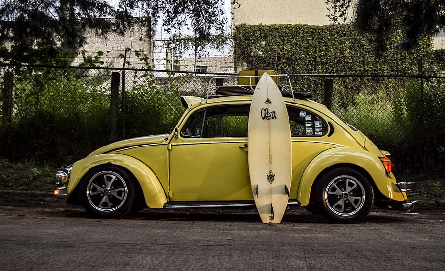 surfboard leaning on yellow car, ocean, sports, sea waves, outdoors