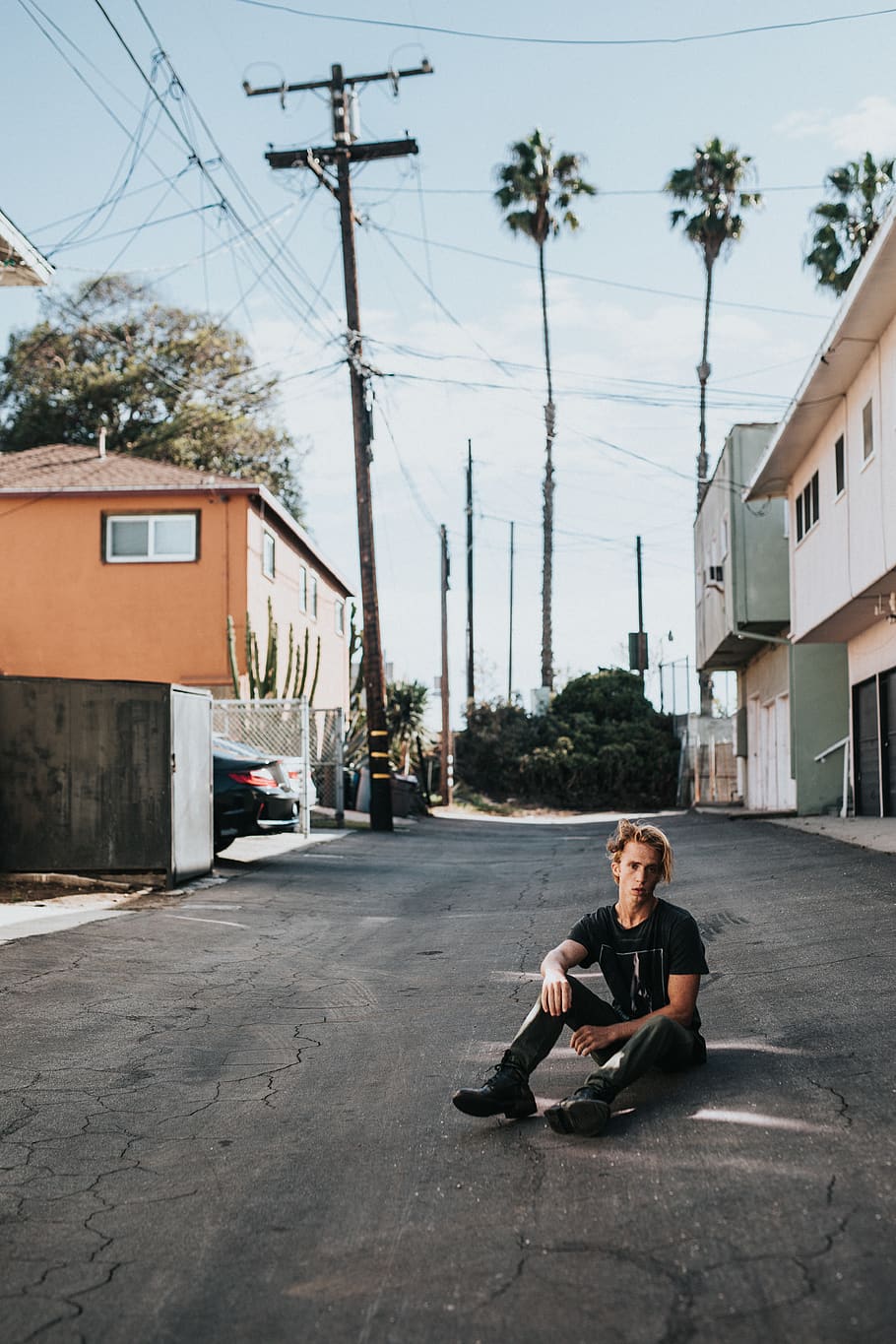 man sitting on pavement, human, person, road, urban, building HD wallpaper