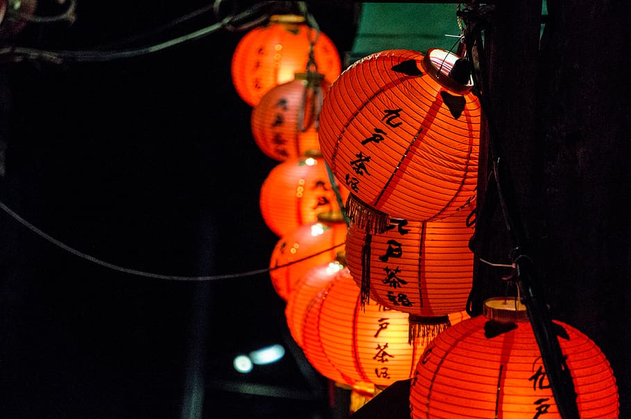 turned-on orange Chinese Lanterns hanging on street during nighttime