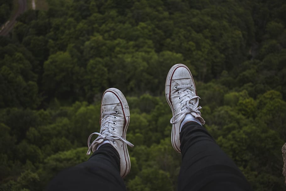 person sitting on cliff while wearing white shoes, foot, tree HD wallpaper