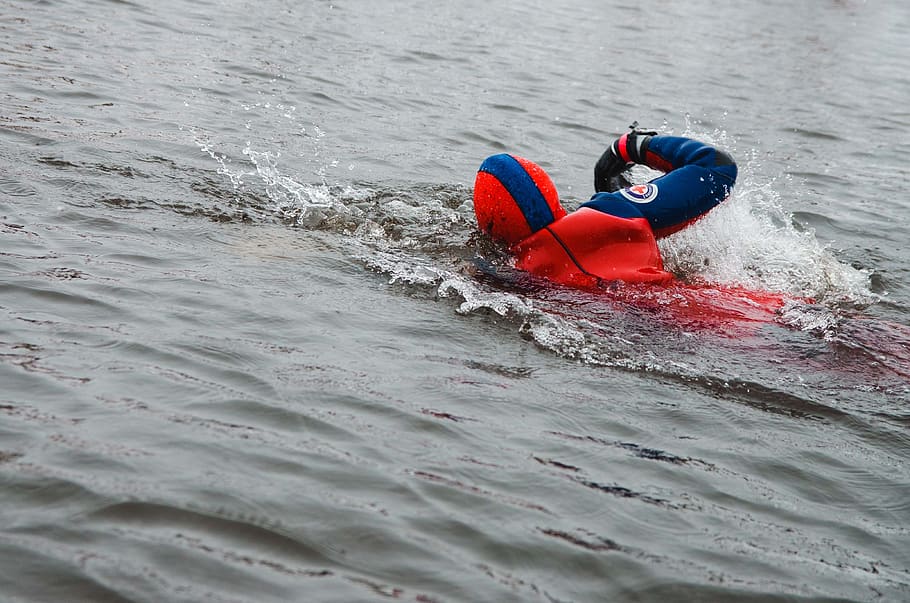 person swimming in body of water, clothing, apparel, vest, lifejacket