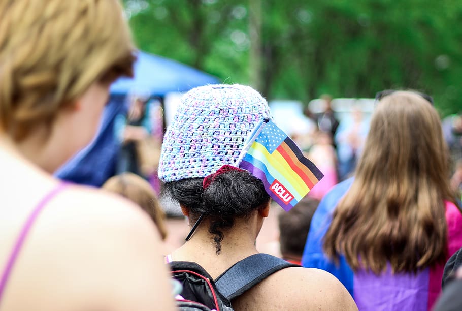 Selective Focus Photography of Woman With Lgbt Flaglet on Her Hair