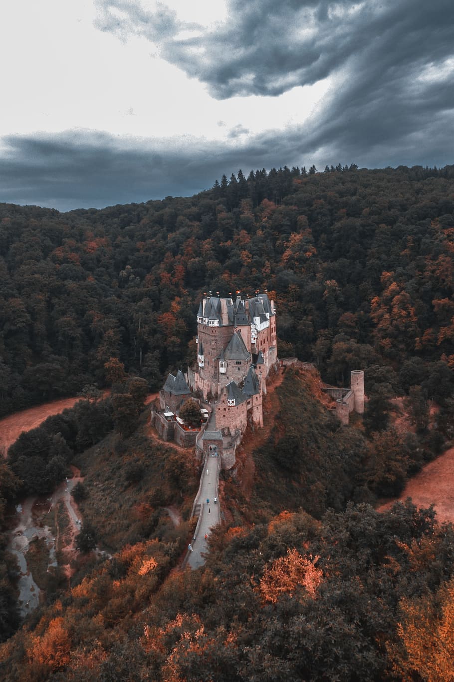 concrete castle surrounded with trees under gray and white clouds during daytime HD wallpaper