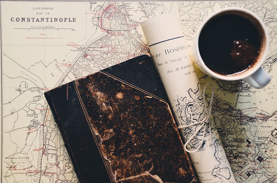 Black Coffee in Mug Near Rolled Paper and Hardbound Book, beverage