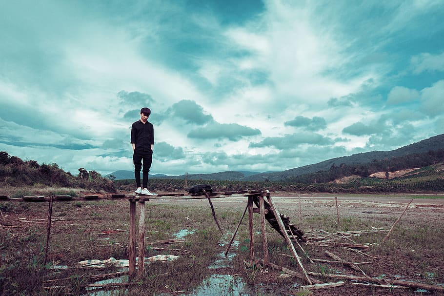 Man Standing on Brown Wooden Stand With Mountain at Distance HD wallpaper