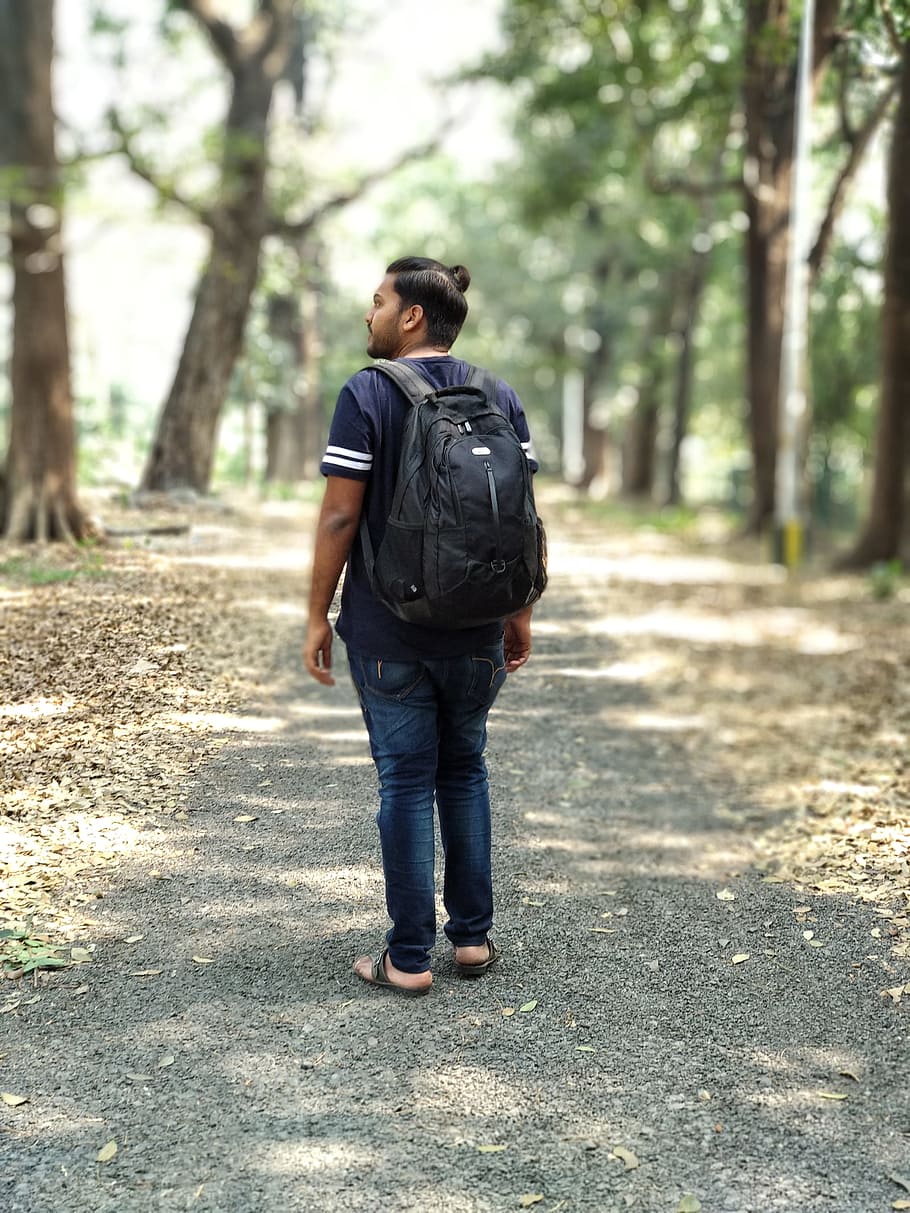 Man in Black and White T-shirt and Blue Denim Jeans Carrying Backpack HD wallpaper