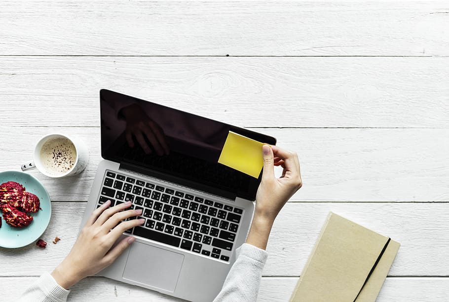 Person Holding Black And Grey Laptop Computer On Top Of White Wood Surface HD wallpaper