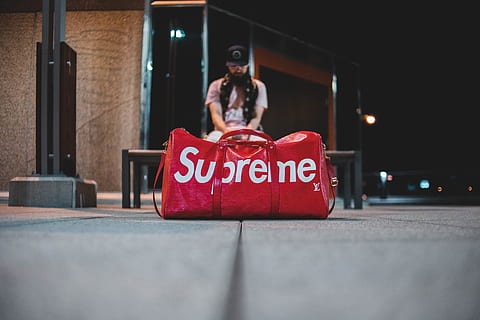 HD wallpaper: man sitting on stairs with red Louis Vuitton X Supreme  leather duffel bag