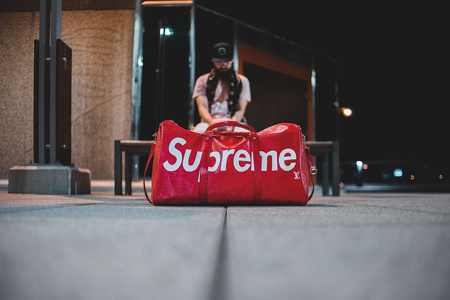 HD wallpaper: person holding red and white Supreme leather duffel bag  outdoor