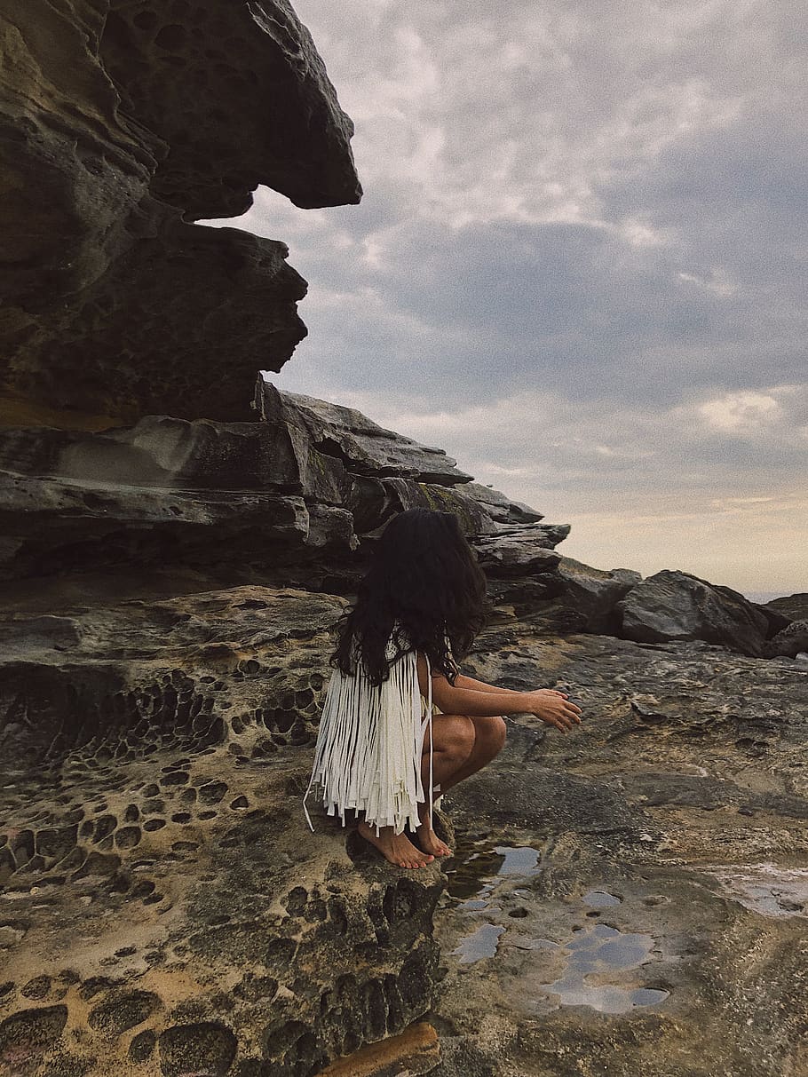 Selective Focus Photography of Woman Sitting on Rock Formation HD wallpaper