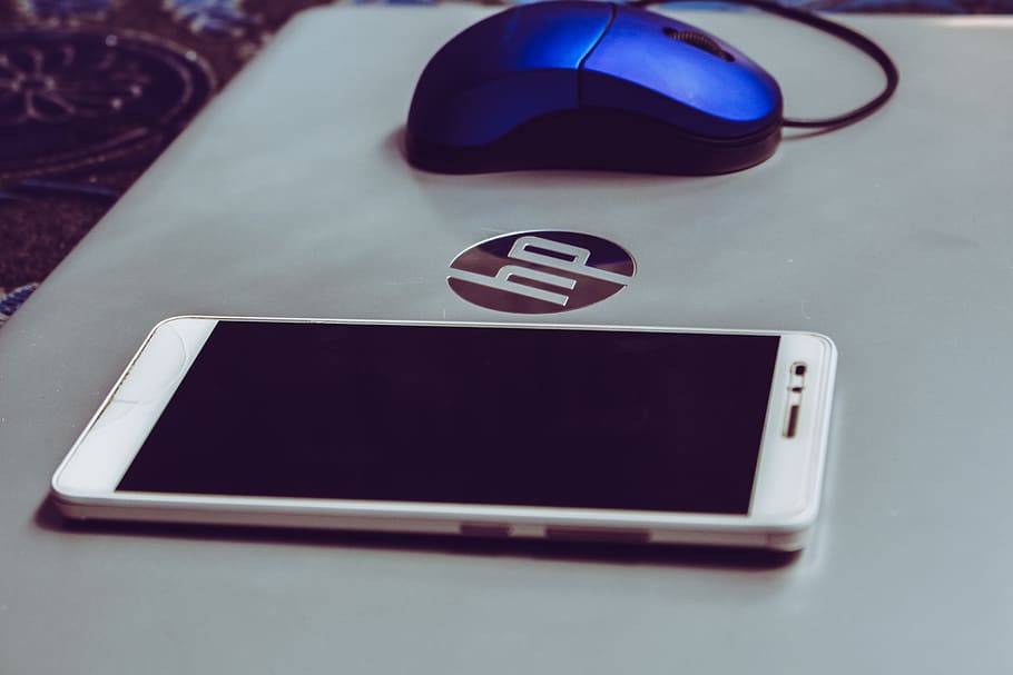 Smartphone On Top Of Grey Hp Laptop , cellphone, device, electronics HD wallpaper