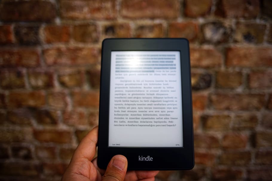 Person Holding Amazon Kindle Ebook, brickwall, contemporary, device