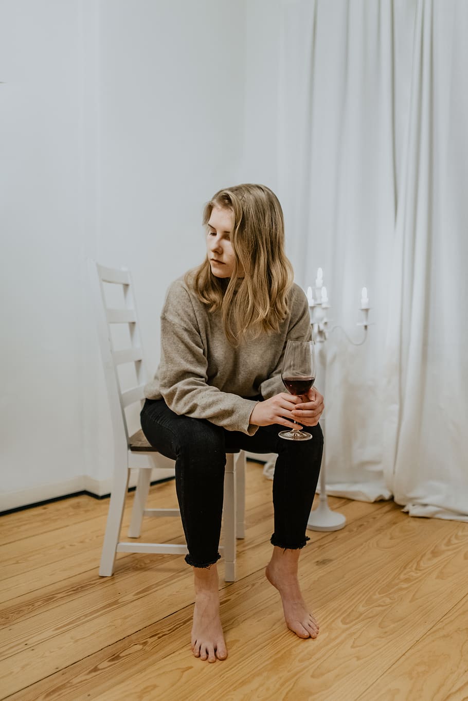 woman-sitting-beside-on-white-chair-holding-wine-glass.jpg