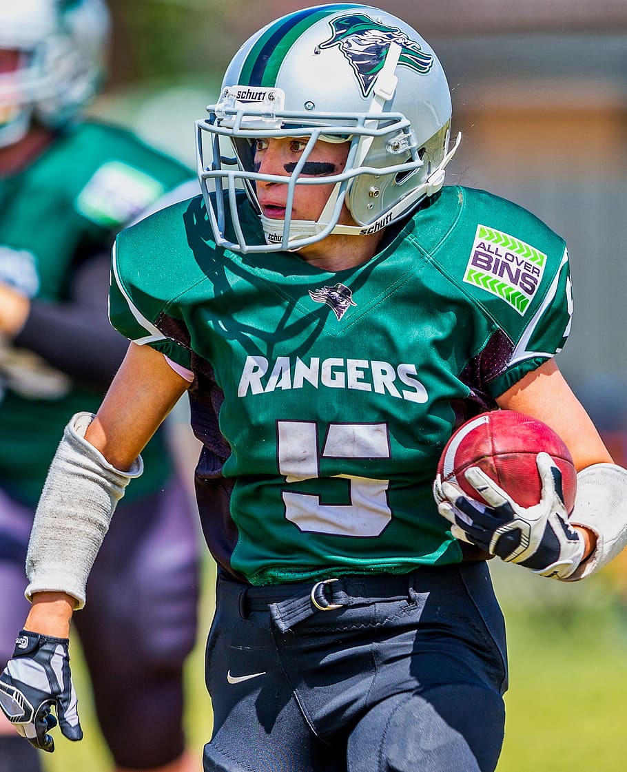 HD wallpaper: man in green Rangers football uniform holds ball, helmet, headwear - Wallpaper Flare