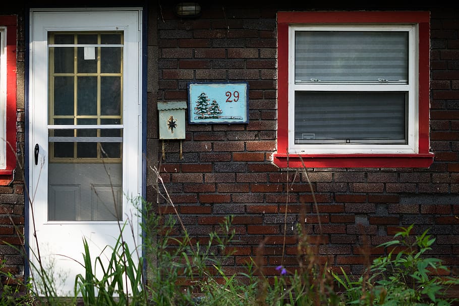 closed white wooden door beside plants, home decor, window, brick