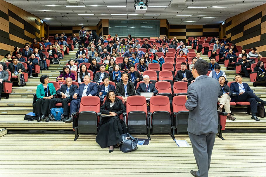 Man Standing In Front Of People , audience, auditorium, chairs HD wallpaper