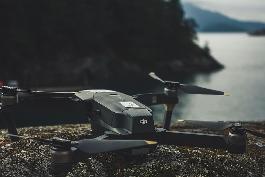 black quadcopter on rock, water, focus on foreground, day, nature HD wallpaper