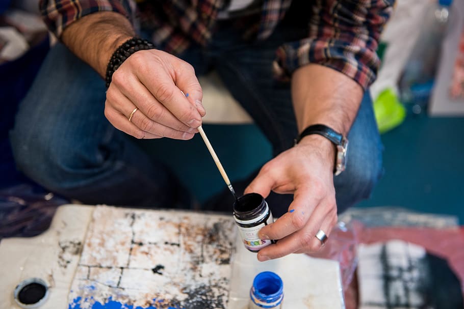 person holding paint bottle and paint brush, human, finger, wood