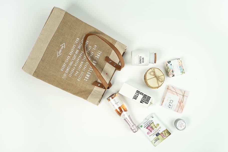 A brown bag full of various items, boxed water, first aid, text, HD wallpaper