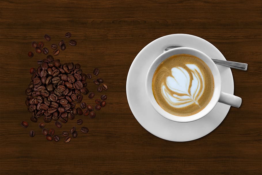 Brown and White Espresso in White Coffee Mug Beside Coffee Beans HD wallpaper