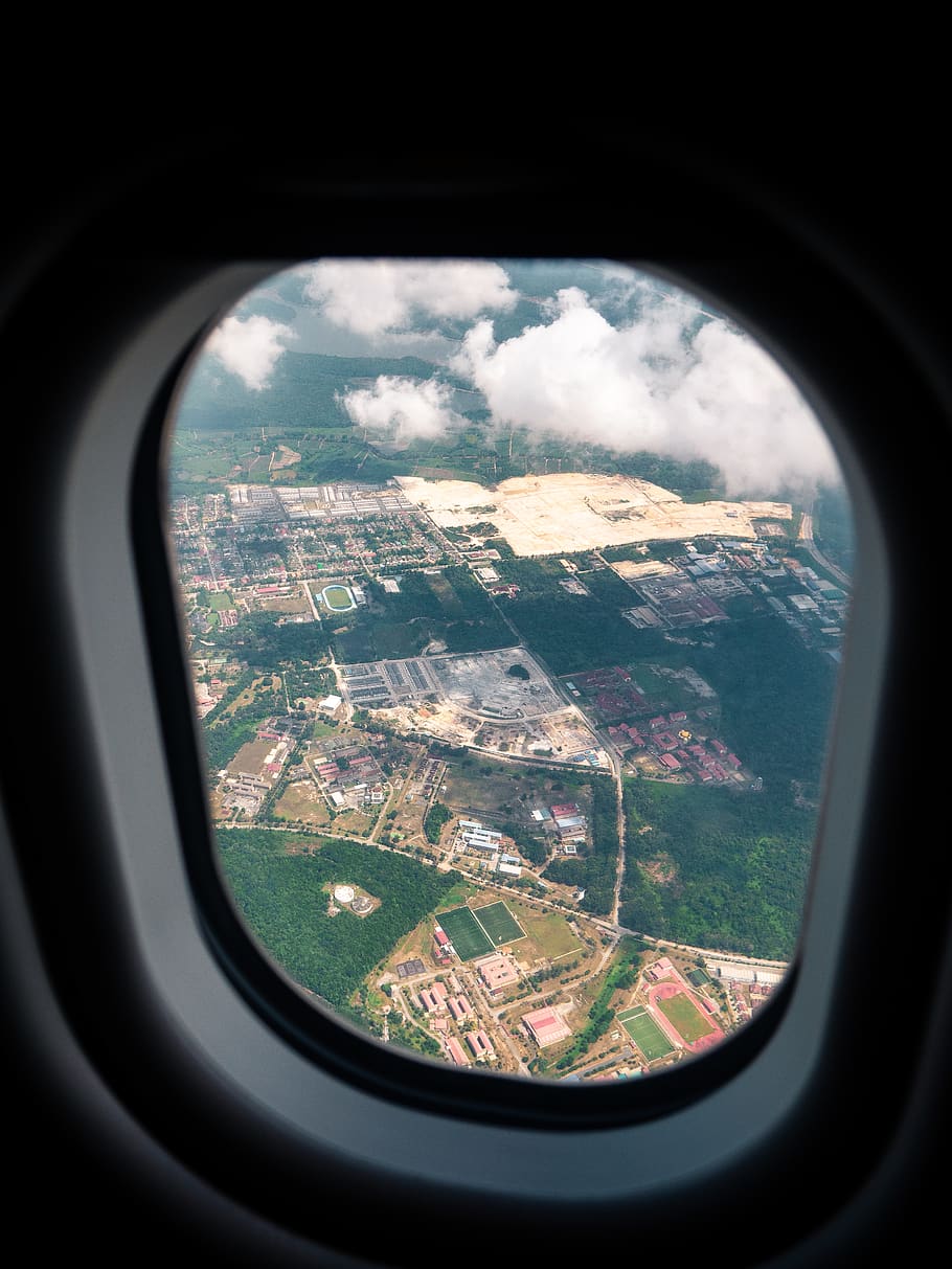 aerial photography of rural area through plane window, porthole