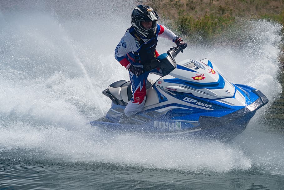 man riding blue and white personal watercraft on sea, human, apparel