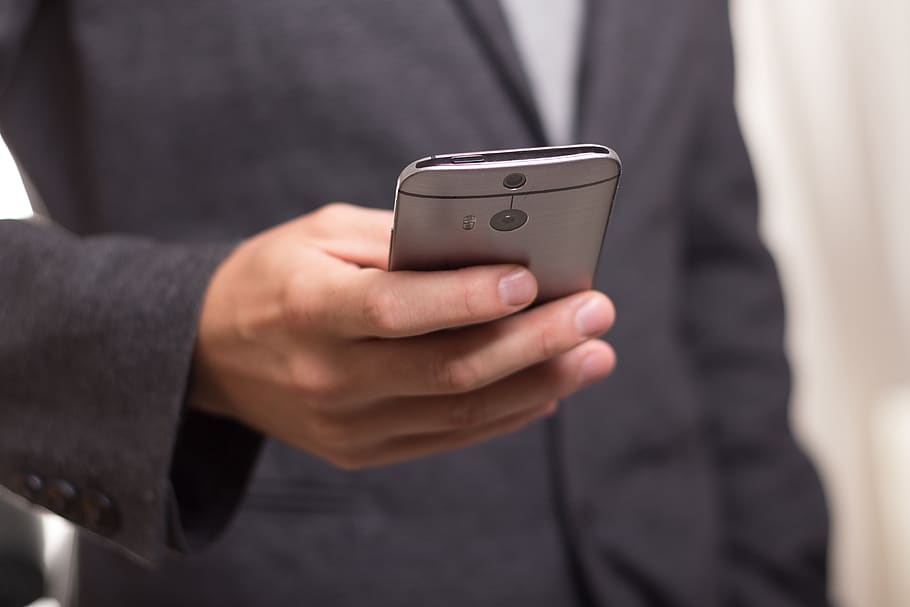 Man Wearing Black Suit Jacket Holding Gray Htc Android Smartphone HD wallpaper