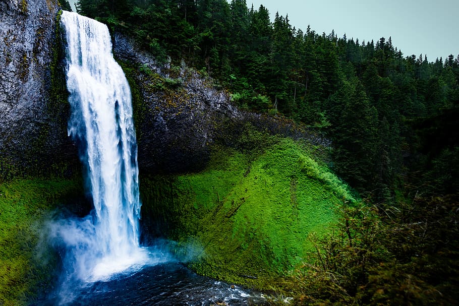 waterfalls plowing on rock formation near green trees, hill, stream HD wallpaper