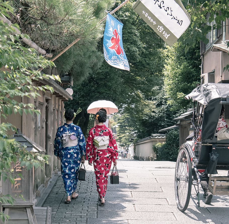 Two Woman Wearing Kimono Dress Walking Beside Sidewalk, carriage