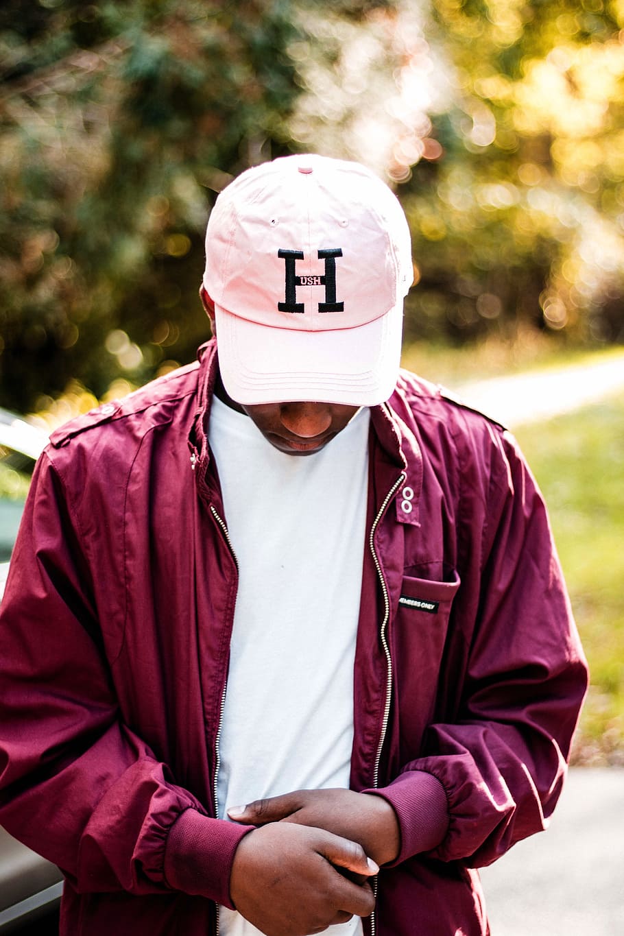 man in maroon jacket and white H fitted cap, one person, focus on foreground HD wallpaper