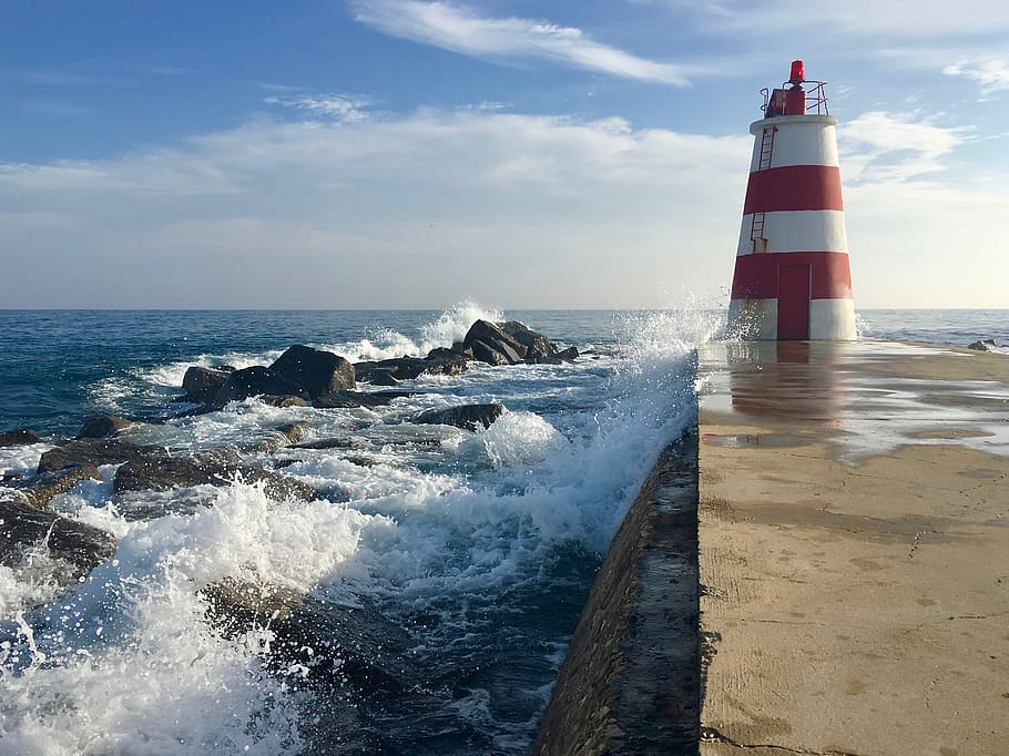 clouds, sky, ocean, lighthouse, pier, rocks, splashes, water HD wallpaper