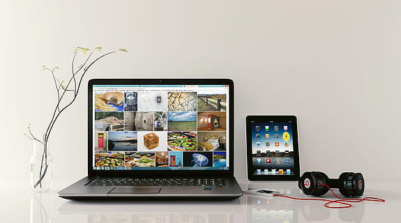 Open laptop displaying web browser and website with photo grid. HD wallpaper