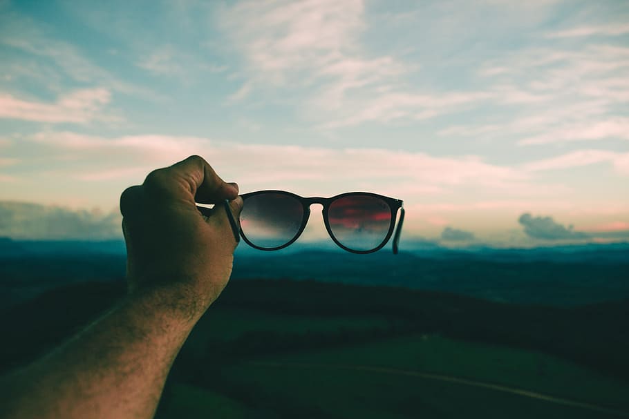 Person Holding Black Framed Sunglasses Under Blue Sky and White Clouds HD wallpaper