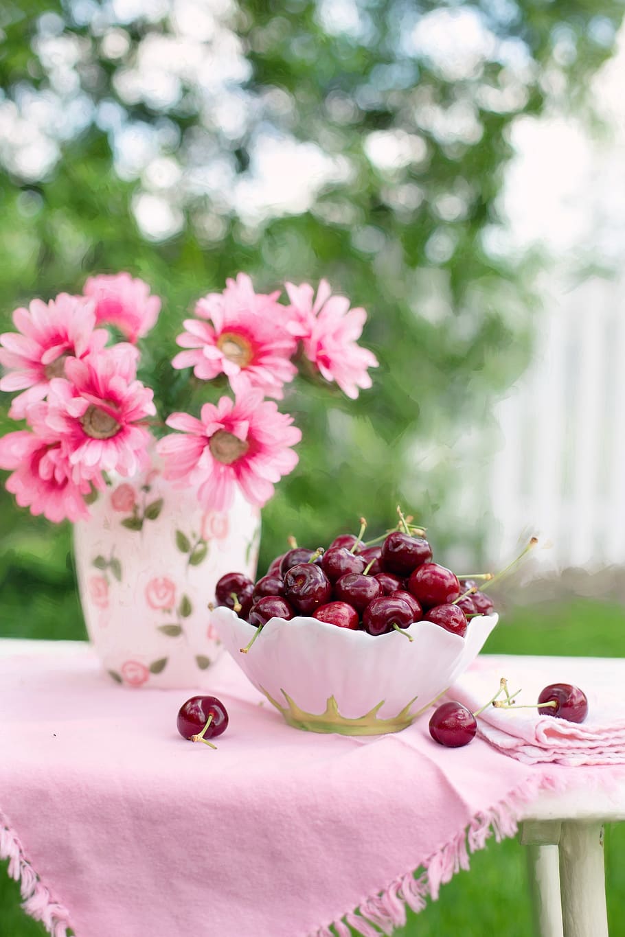 Pink Petaled Flower Beside White and Green Bowl Full of Cherry HD wallpaper