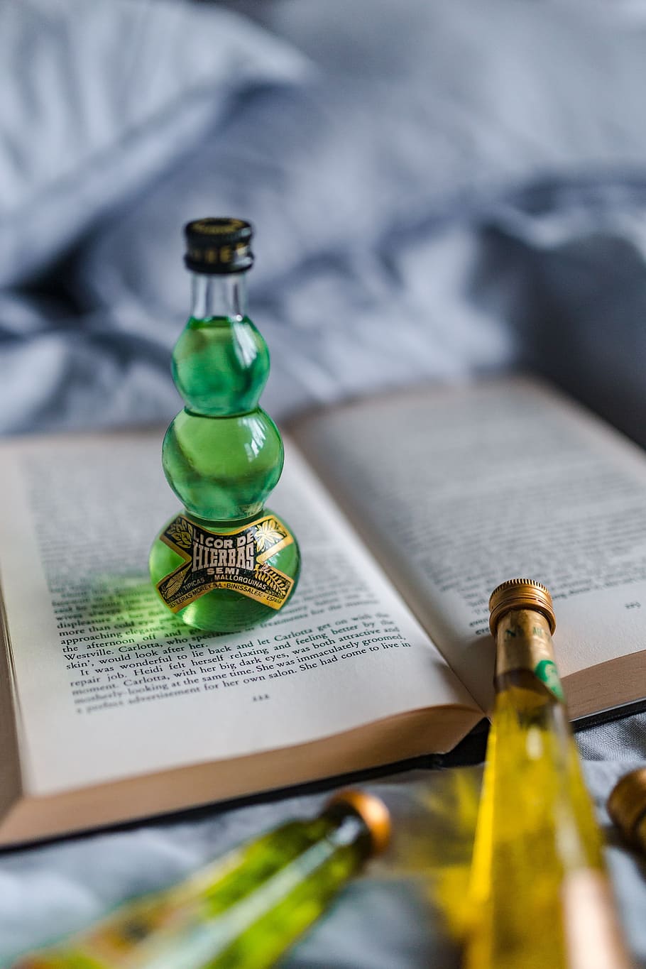 Group of colorful little bottles with liqueurs, book, drink, read