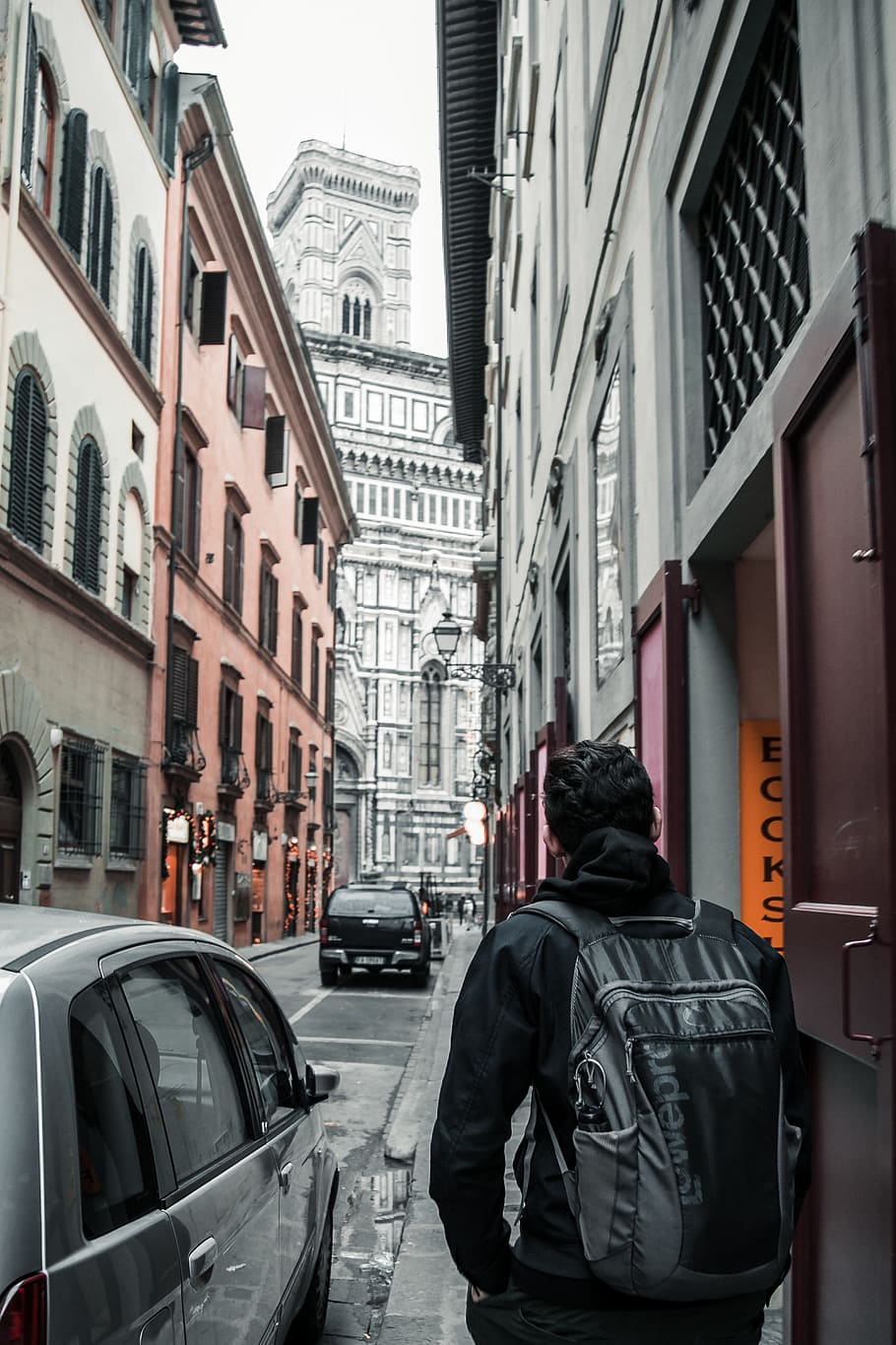 Man Wearing Black Hoodie And Backpack Near Building And Parked Car HD wallpaper