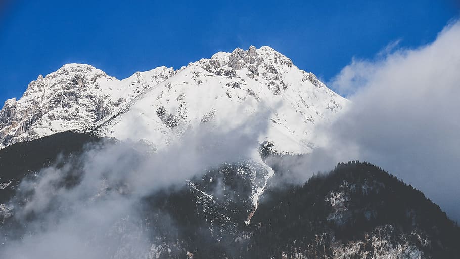 snowy mountain covered by clouds during daytime, forest, blue sky HD wallpaper