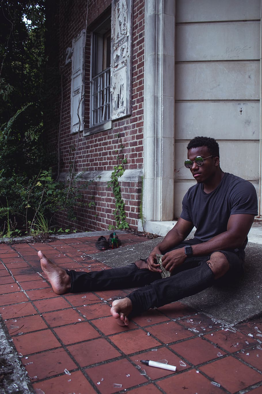 Man in Black T-shirt Wearing Sunglasses While Sitting in Front of Door HD wallpaper