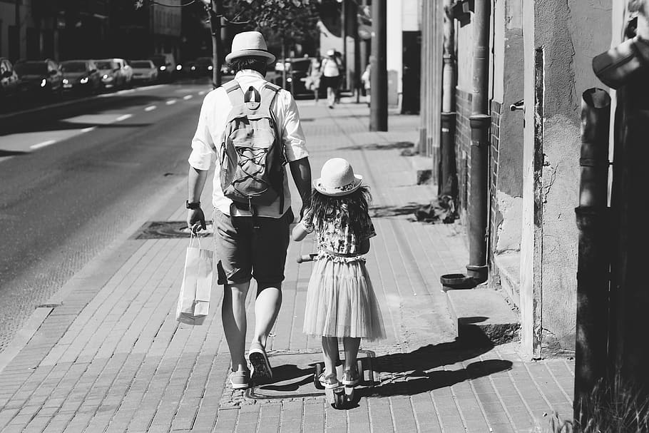Man Holding Girl While Walking on Street, backpack, black and white HD wallpaper