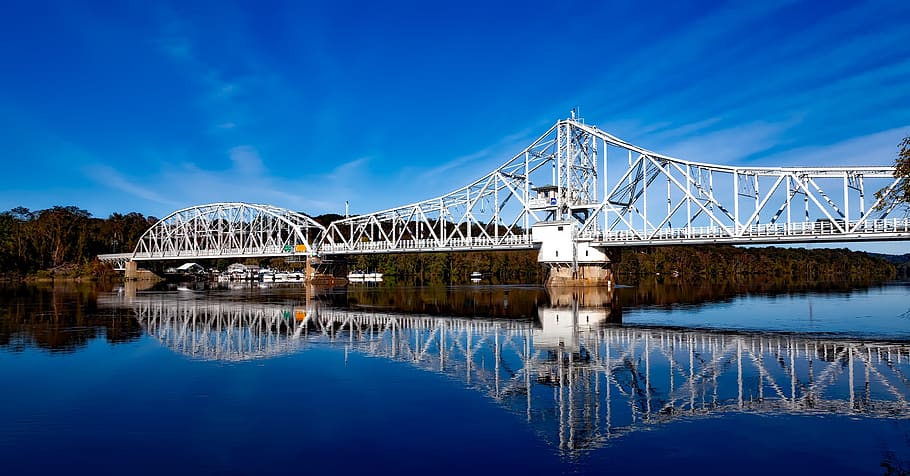 White Bridge Above Body of Water Creating a Reflection Under White Clouds HD wallpaper