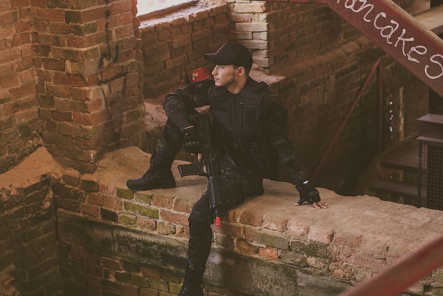 Man In Black Safety Gears Holding Airsoft Gun, bricks, building HD wallpaper