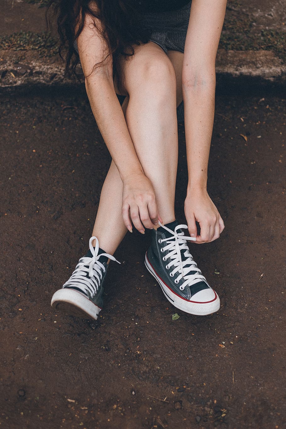 Photo of Woman Tying Her Shoelaces, converse all star, footwear