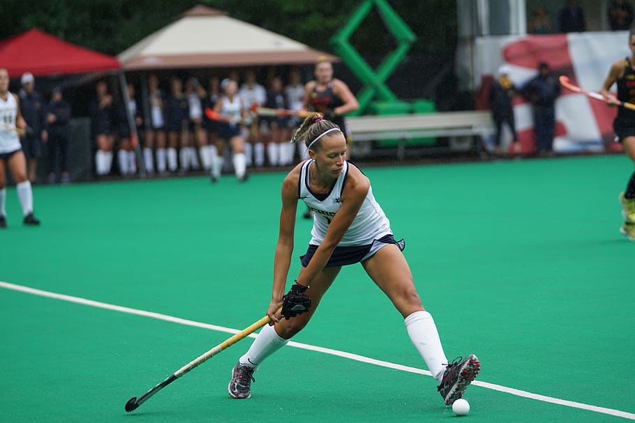 woman holding hockey stick on field, sport, green color, leisure activity
