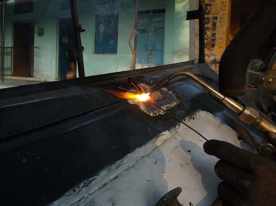 person welding black metal part, fire, metal work, industrial HD wallpaper