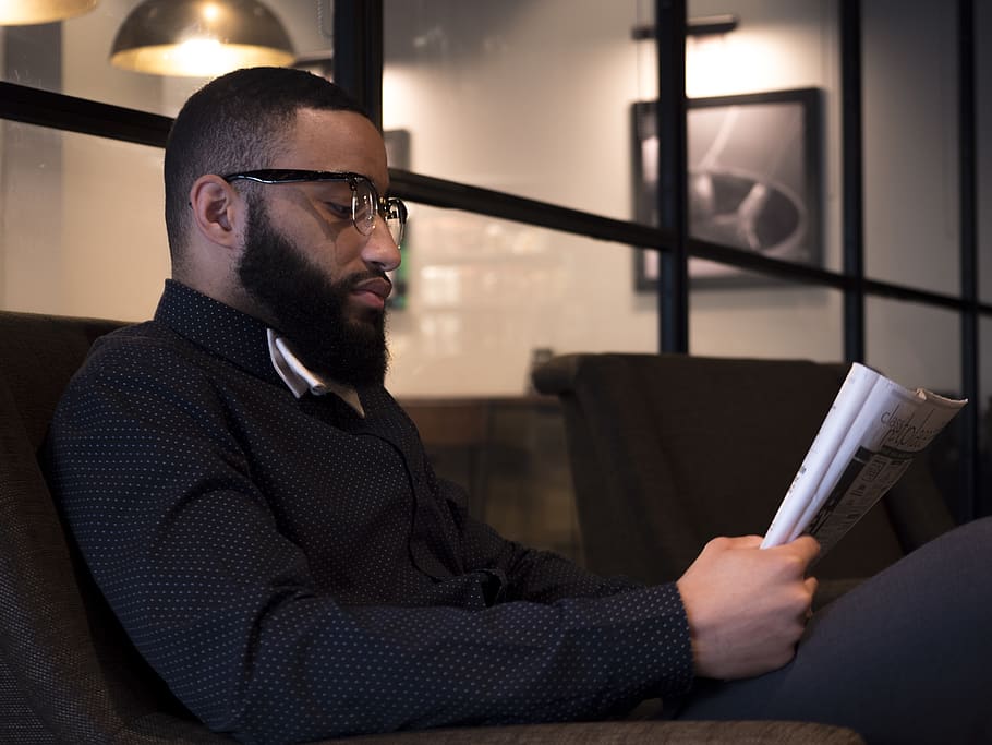 man sitting on sofa while reading book, glasses, eyeglasses, one person HD wallpaper