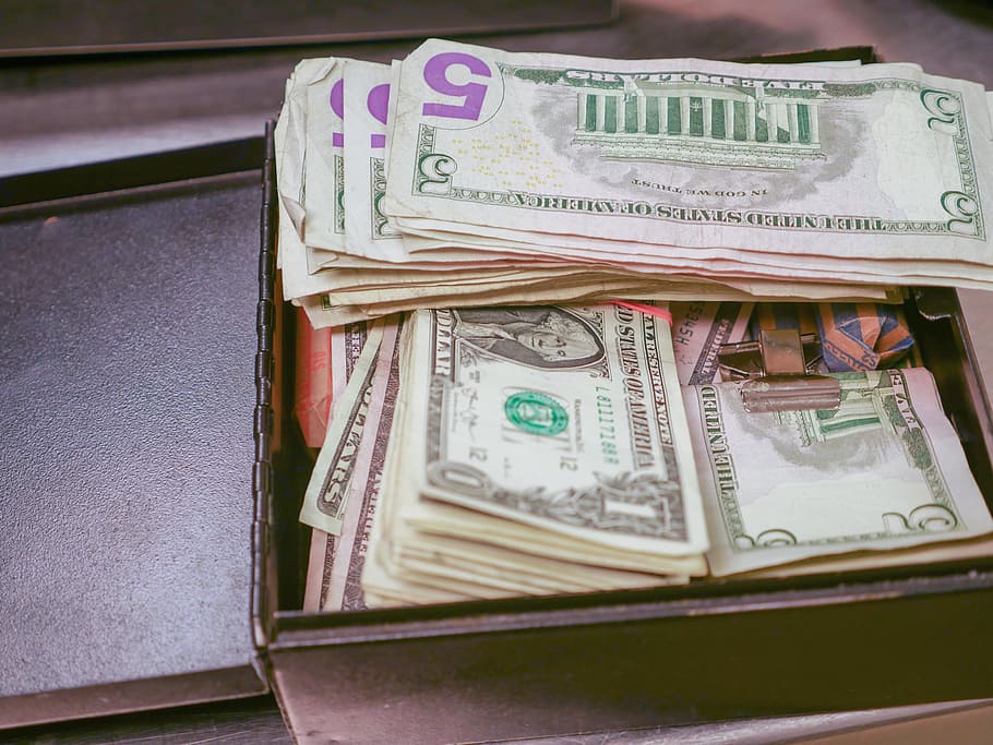 Stacks of cash in a black metal box, money, retail, register