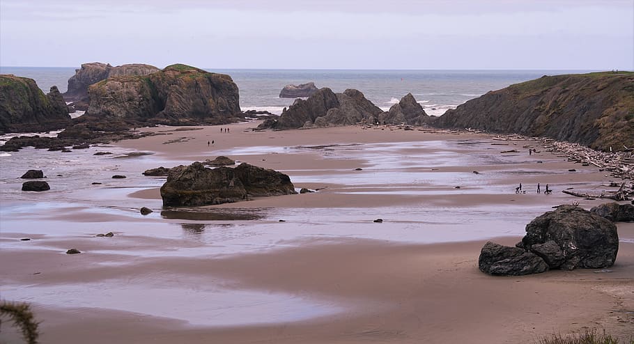brown sand beach bounded with rocks, shoreline, water, outdoors HD wallpaper