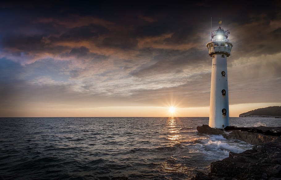 lighthouse, glow, evening, sunset, ocean, sea, horizon, distant HD wallpaper